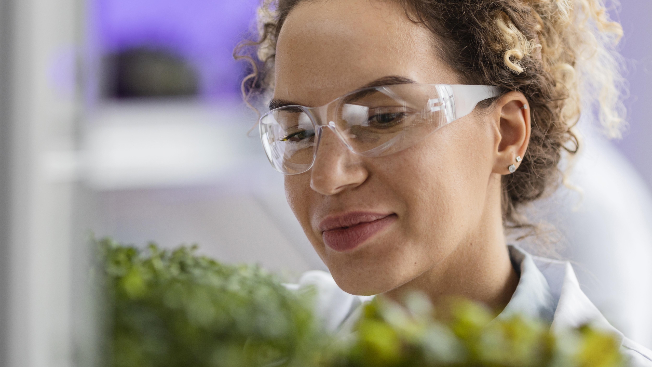 smiley-female-researcher-laboratory-with-safety-glasses-plant